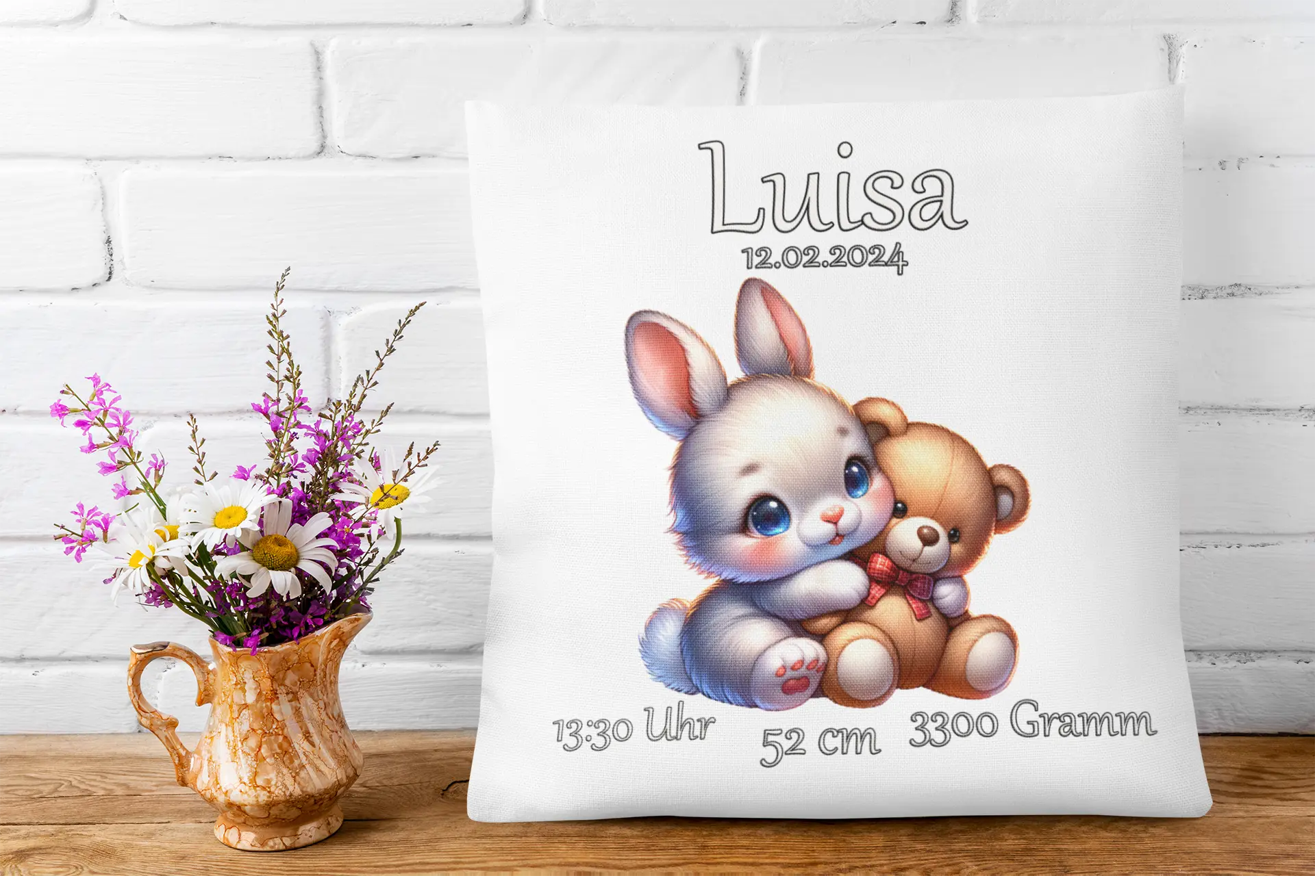 Kuschelkissen zur Geburt mit Hase und Kuschelbär – liebevoll gestaltetes Tiermotiv mit großen blauen Augen, ergänzt durch Uhrzeit, Größe, Gewicht und Geburtsdatum.