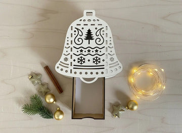 Geschenkschachtel Glocke aus Holz mit filigranem Laserschnitt auf hellem Hintergrund
