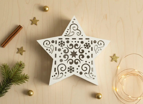 Geschenkschachtel Sternform mit goldenen Kugeln und Tannenzweig auf Holzuntergrund