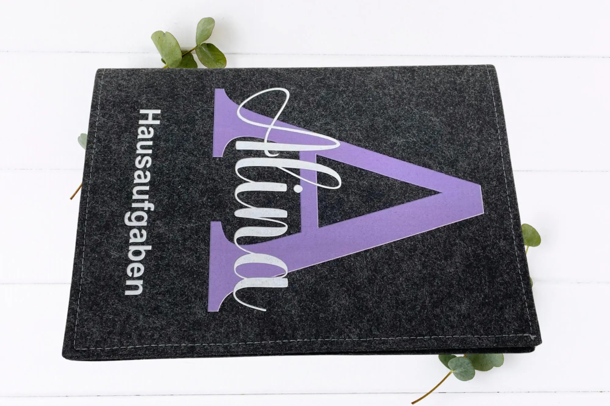 Robuste Schulheft-Hüllen aus Filz mit großem Buchstaben und klarer Typografie.