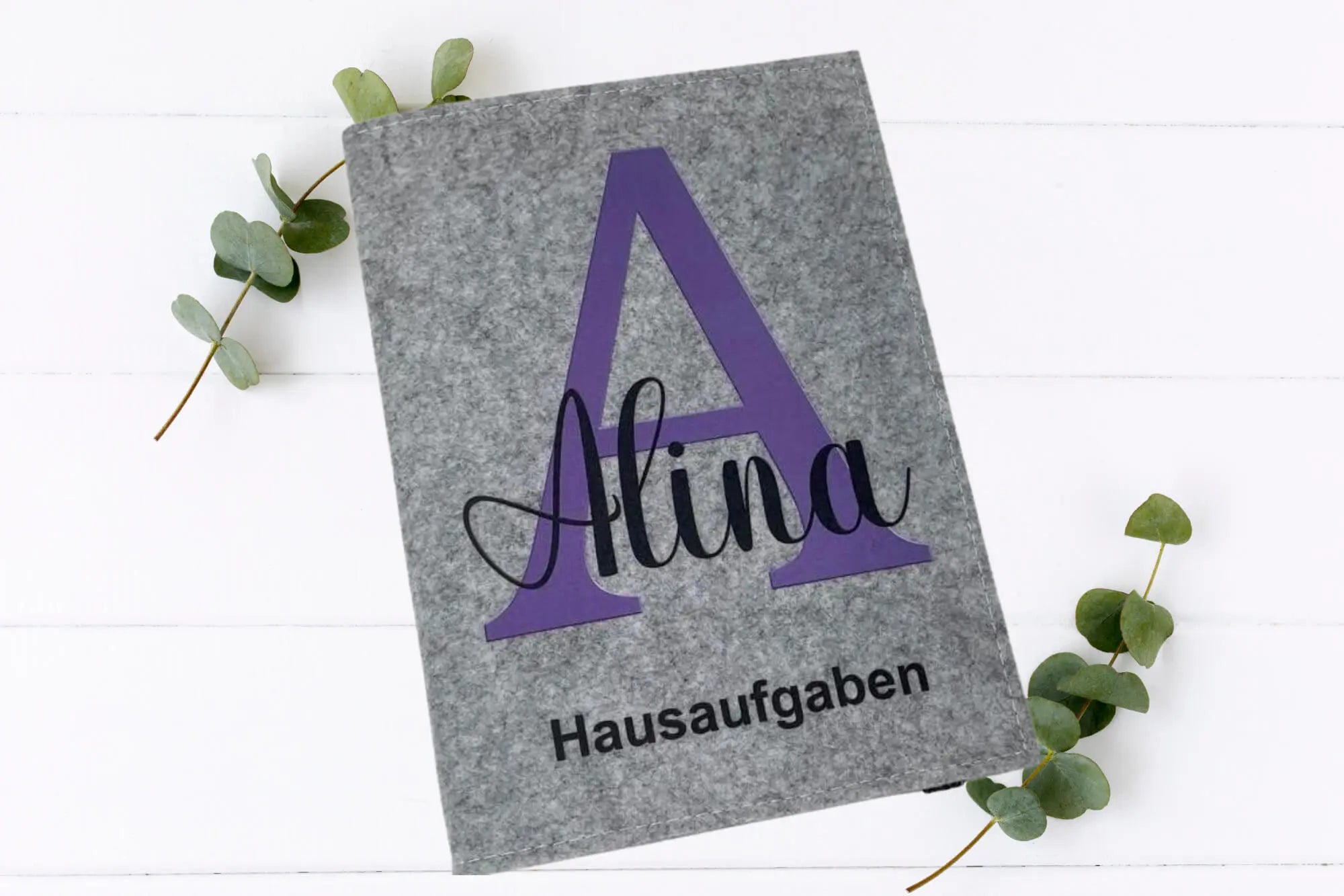 Schlichte, stilvolle Hausaufgabenhüllen mit typografischem Initial auf Filz.