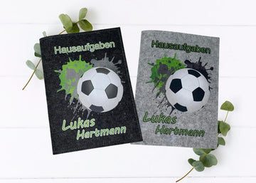 Zwei Filzhüllen für Hausaufgabenhefte mit Fußballmotiv und grünen Farbspritzern.