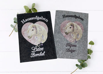 Zwei Filzhüllen für Hausaufgabenhefte mit edlem Pferdemotiv im Herzrahmen.