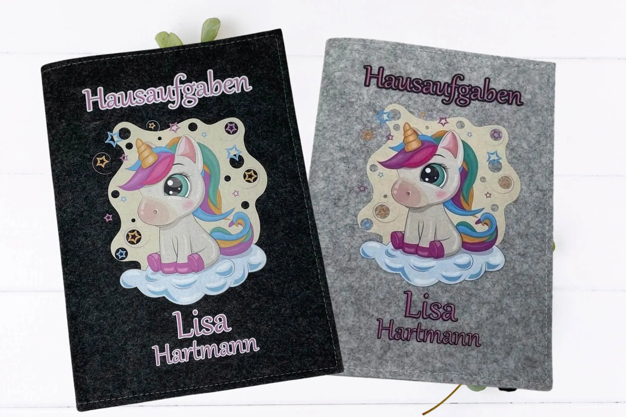 Hausaufgabenheft mit bunter Einhorn-Illustration auf einer Wolke – gedruckt auf Filzhülle.