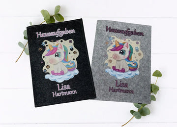 Filzhüllen für Hausaufgabenhefte mit niedlichem Einhornmotiv auf schwarzem und grauem Hintergrund.