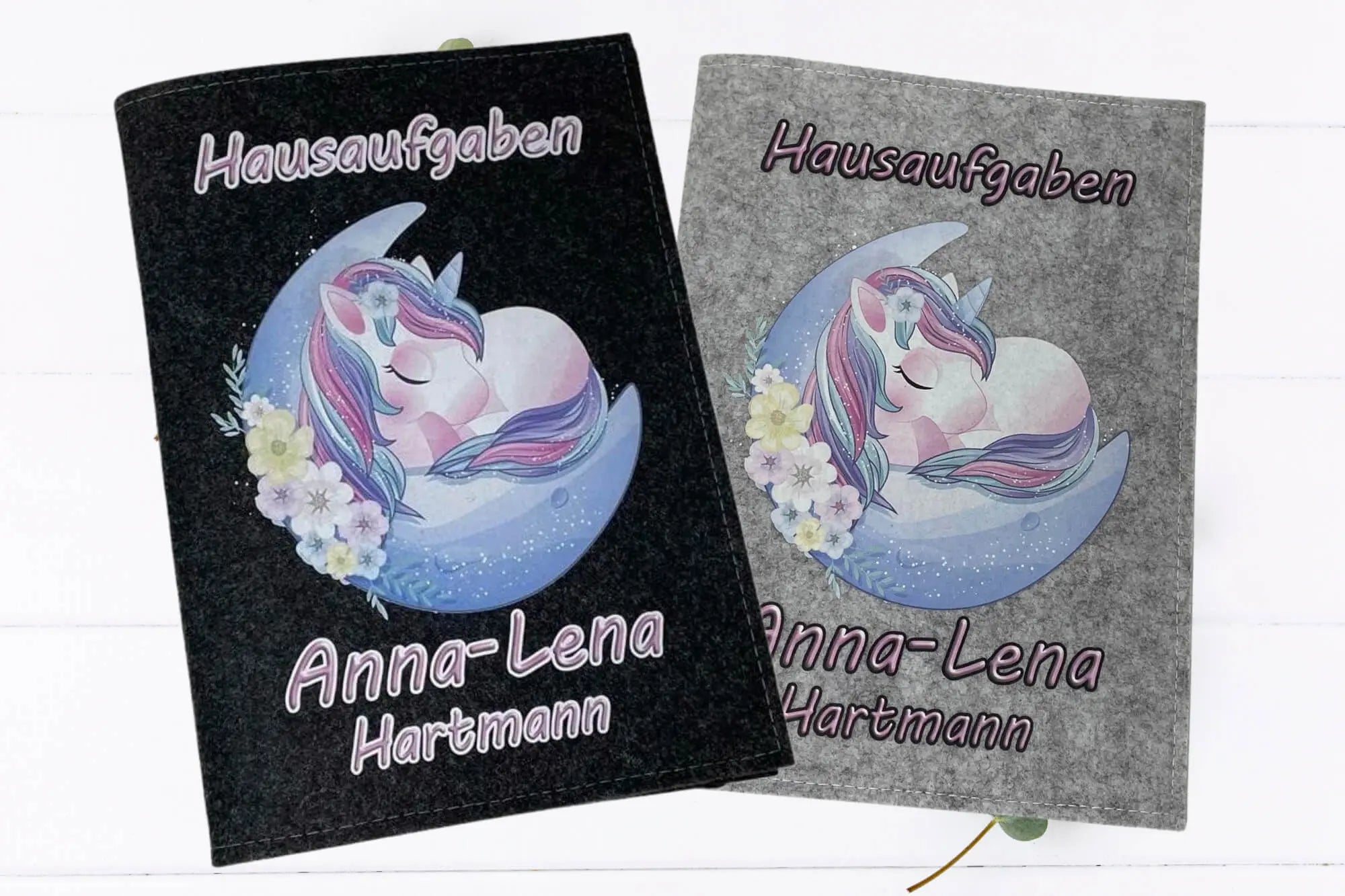 Hausaufgabenheft-Hüllen aus grauem und schwarzem Filz mit schlafendem Einhorn auf Halbmond.