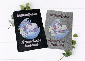 Zwei Filzhüllen für Hausaufgabenhefte mit Einhorn motiv auf Mondsichel und floralen Details.