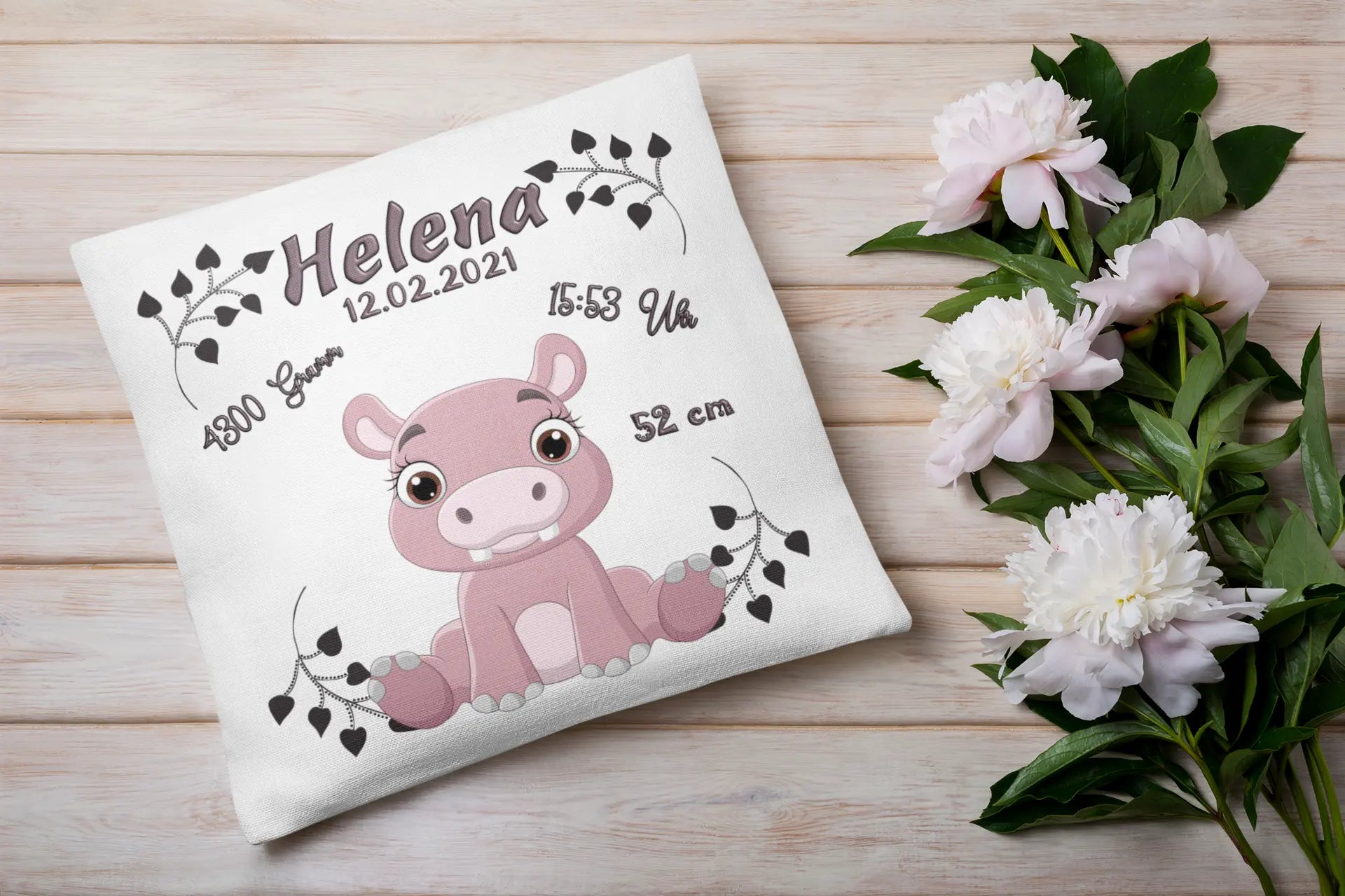 Erinnerungskissen mit Nilpferdbaby in Rosa – dekoratives Babykissen mit niedlichem Flusspferd und schwarzer Blattverzierung, ideal zur Geburt.