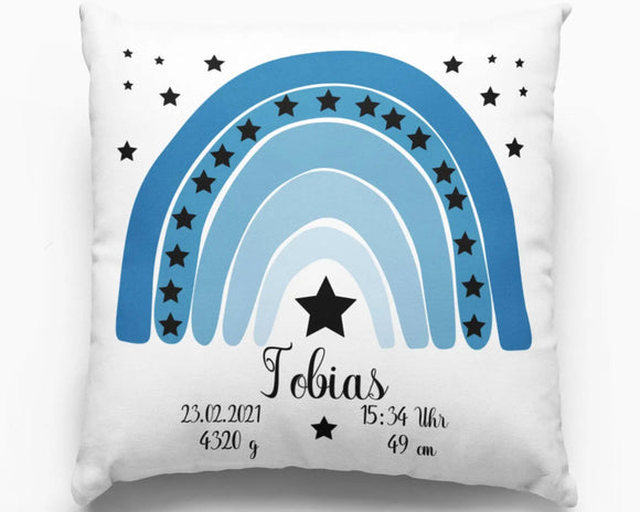 Geburtskissen mit blauem Regenbogen und Sternen – stilisiertes Regenbogenmotiv in verschiedenen Blautönen, verziert mit schwarzen Sternen und Geburtsdaten.