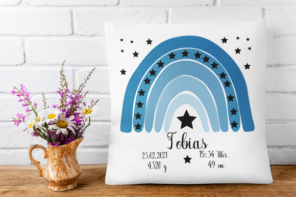 Zierkissen zur Geburt mit abstraktem Himmelsmotiv in Blau – harmonisches Regenbogendesign mit vielen kleinen schwarzen Sternen und zentralem Namensbereich.