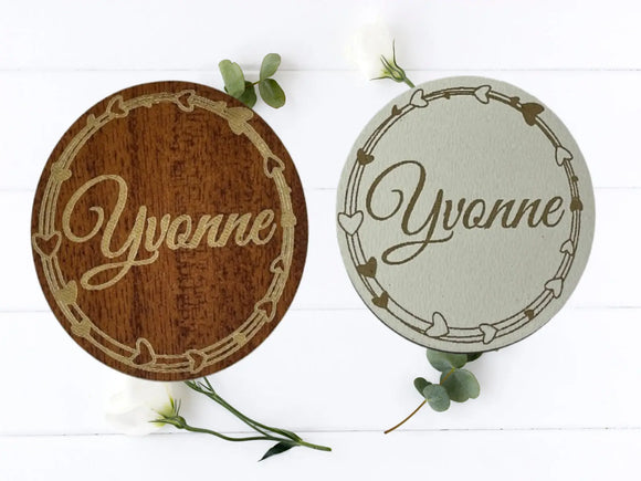 Zwei gravierte Holzscheiben mit Herzkranz und Vornamen – personalisierte Tischdeko zur Hochzeit