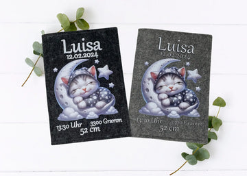 U-Heft-Hülle mit schlafender Katze im Sternenanzug auf Halbmond – liebevolles Design zur Geburt.