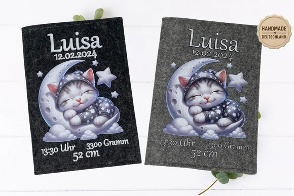 Schlafende Babykatze auf Mondsichel mit Sternen – zauberhafte U-Heft-Hülle aus grauem Filz.