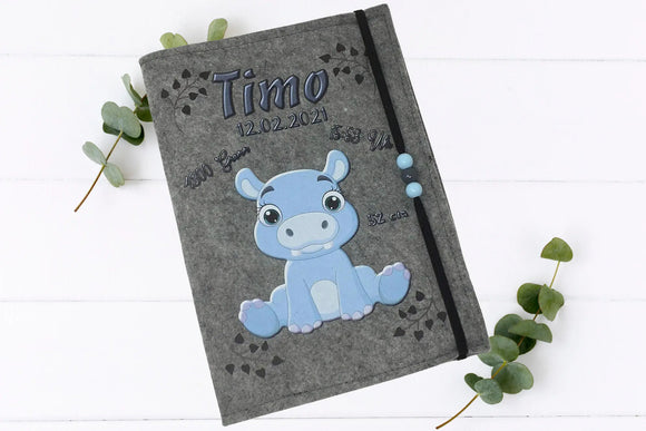 Handgemachte Filzhülle mit blauem Nilpferd, elastischem Band mit blauen Perlen und liebevollem Design.