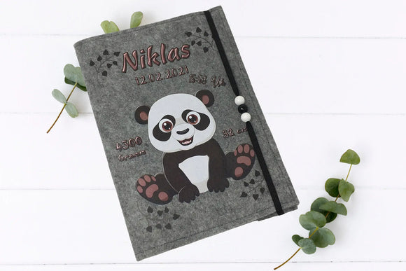 Filzhülle für das Untersuchungsheft mit Panda-Baby, Herzspuren und dekorativen Perlen.
