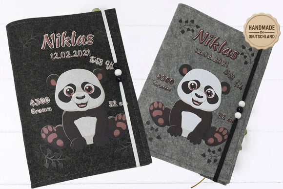Lächelnder Panda mit Tatzen und Herzmuster auf grauer Filzhülle zur Aufbewahrung des Untersuchungsheftes.