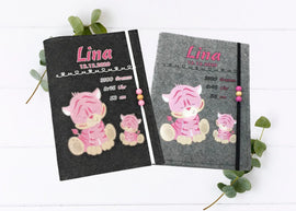 Personalisierte U-Heft-Hülle aus grauem Filz mit zwei niedlichen rosa Tigern und rosa Holzperlen.