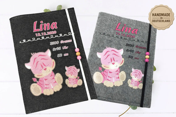 Graue U-Heft-Hülle mit schlafendem Babytiger in Rosa und dekorativen Geburtsdaten.