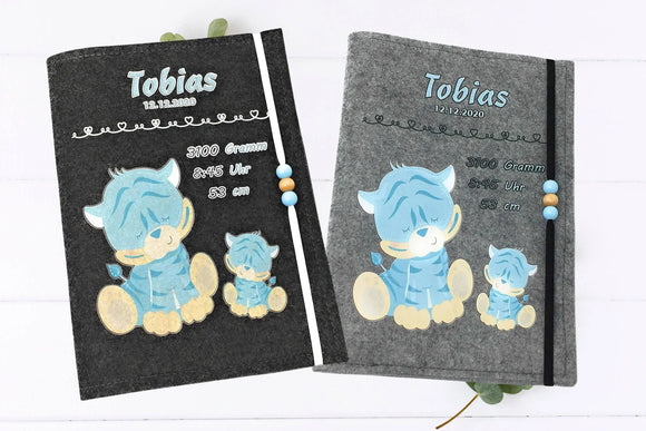 Filzhülle fürs U-Heft mit niedlichem Babytiger in Blau und Holzperlen in Pastelltönen.