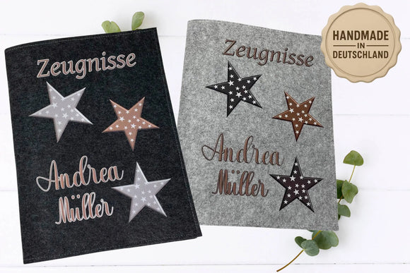 Zwei personalisierte Zeugnismappen mit braunen, grauen und schwarzen Sternen sowie Namensaufdruck in Schreibschrift