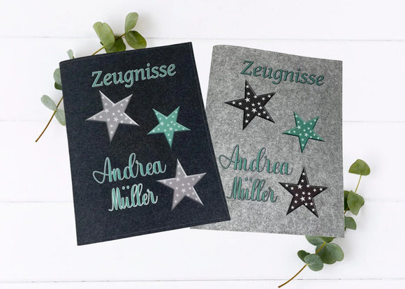 Zwei Zeugnismappen aus Filz mit drei dekorativen Sternen in Mint, Grau und Schwarz auf hellem und dunklem Hintergrund