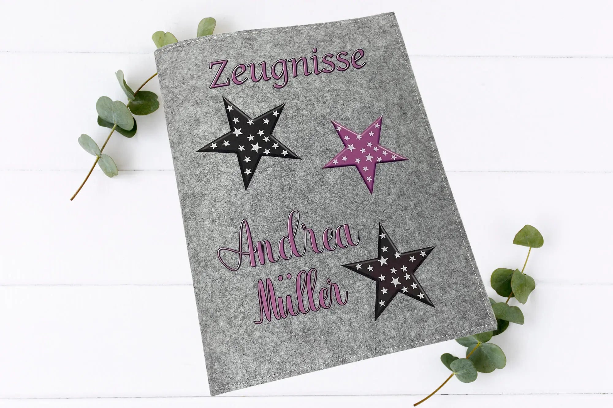 Handgefertigte Zeugnismappen mit auffälligem Sternenmotiv in rosa und weiß – auf Filz in zwei Farbtönen