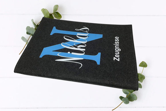 Personalisierte Zeugnismappe mit blauem Buchstabenmotiv – moderner Stil mit Wunschname für Jungen, aus robustem Filz gefertigt.