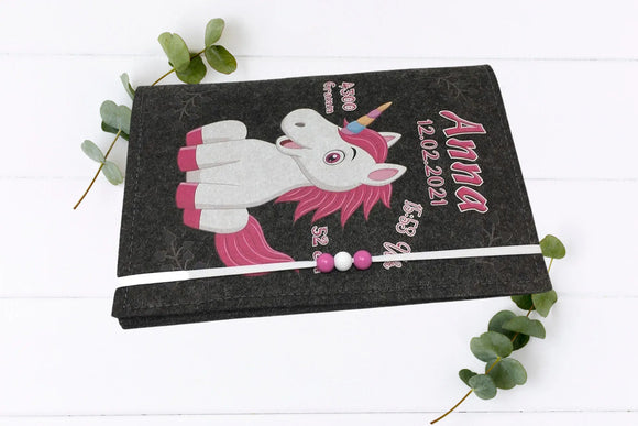 Verspielte Filzhülle für das Untersuchungsheft mit farbenfrohem Einhorn und aufgedruckten Geburtsdaten.