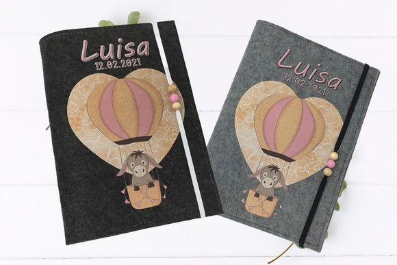 Luftiger Look auf U-Heft-Hülle: Esel im Ballonkorb vor einem herzförmigen Musterballon.