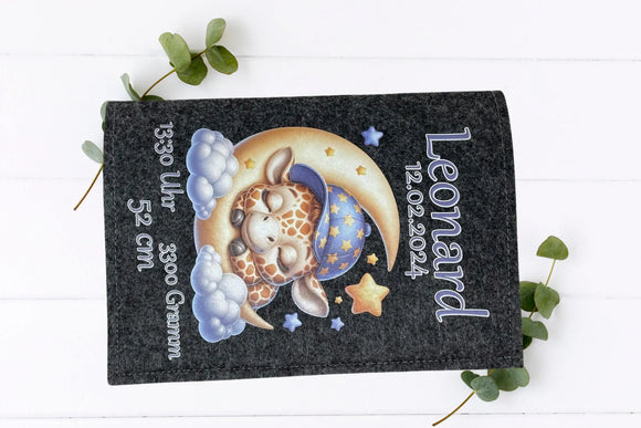 U-Heft-Hülle mit Giraffenbaby im Schlafanzug auf Halbmond, begleitet von Sternen und weichen Wolken.