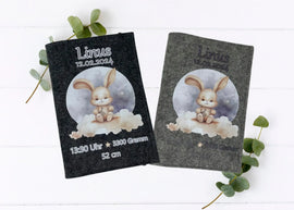 Personalisierte U-Heft-Hülle aus grauem Filz mit süßem Häschen auf einer Wolke vor nächtlichem Himmel.