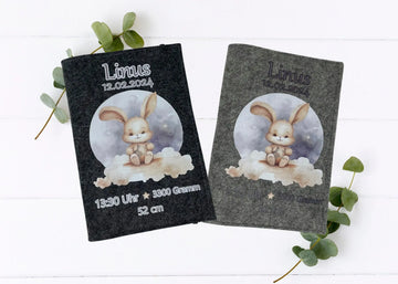 Personalisierte U-Heft-Hülle aus grauem Filz mit süßem Häschen auf einer Wolke vor nächtlichem Himmel.