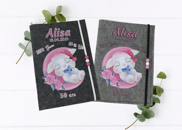 U-Heft-Hülle aus grauem Filz mit schlafendem Häschen auf rosa Mond – liebevolles Baby-Design.