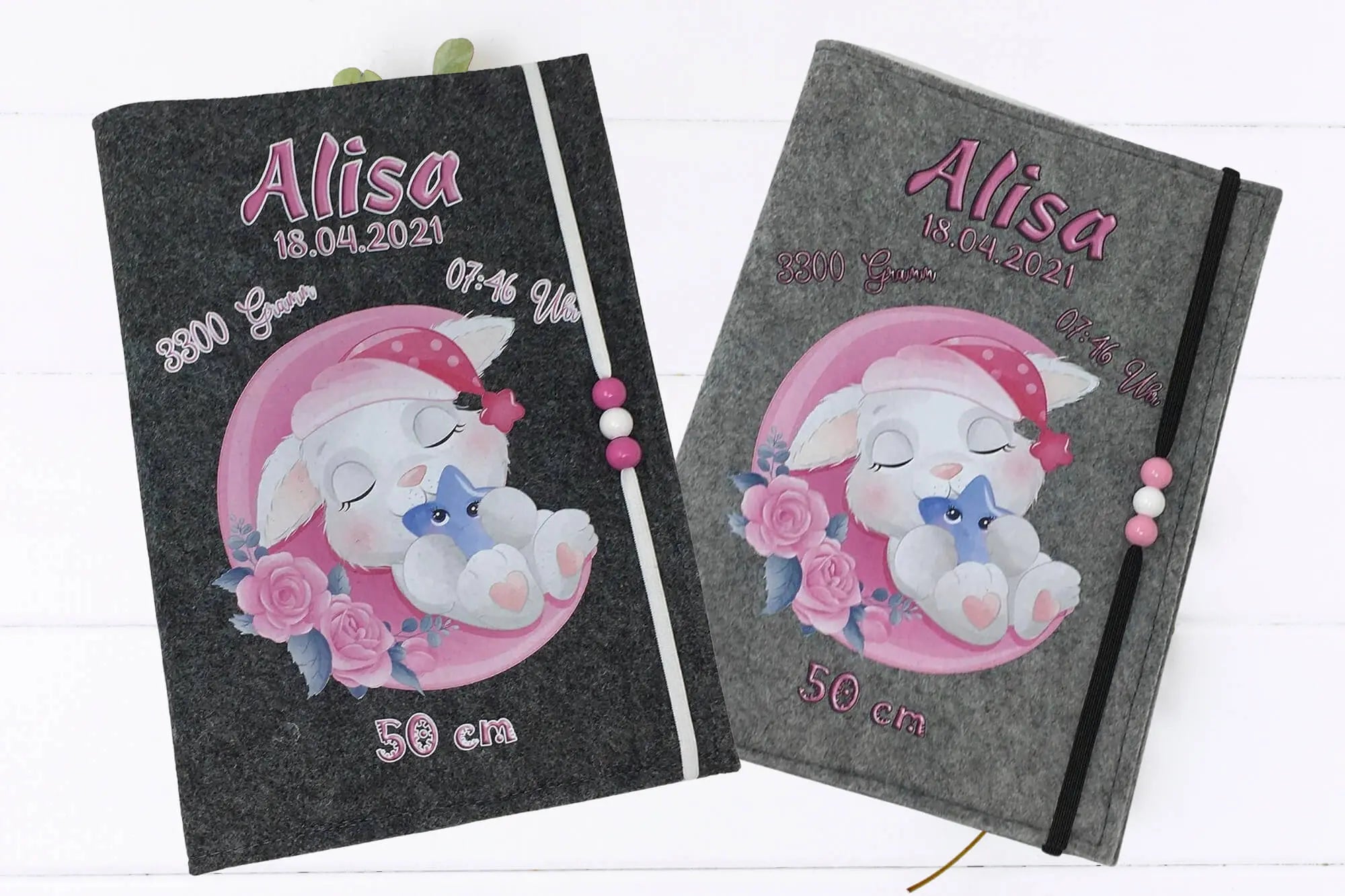Filzhülle fürs U-Heft mit Hase auf Halbmond, rosa Blumen und Kuschelstern in der Pfote.