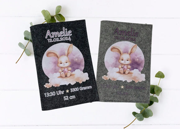 Personalisierte U-Heft-Hülle aus grauem Filz mit süßem Hasen auf Wolke vor rosa-violettem Nachthimmel