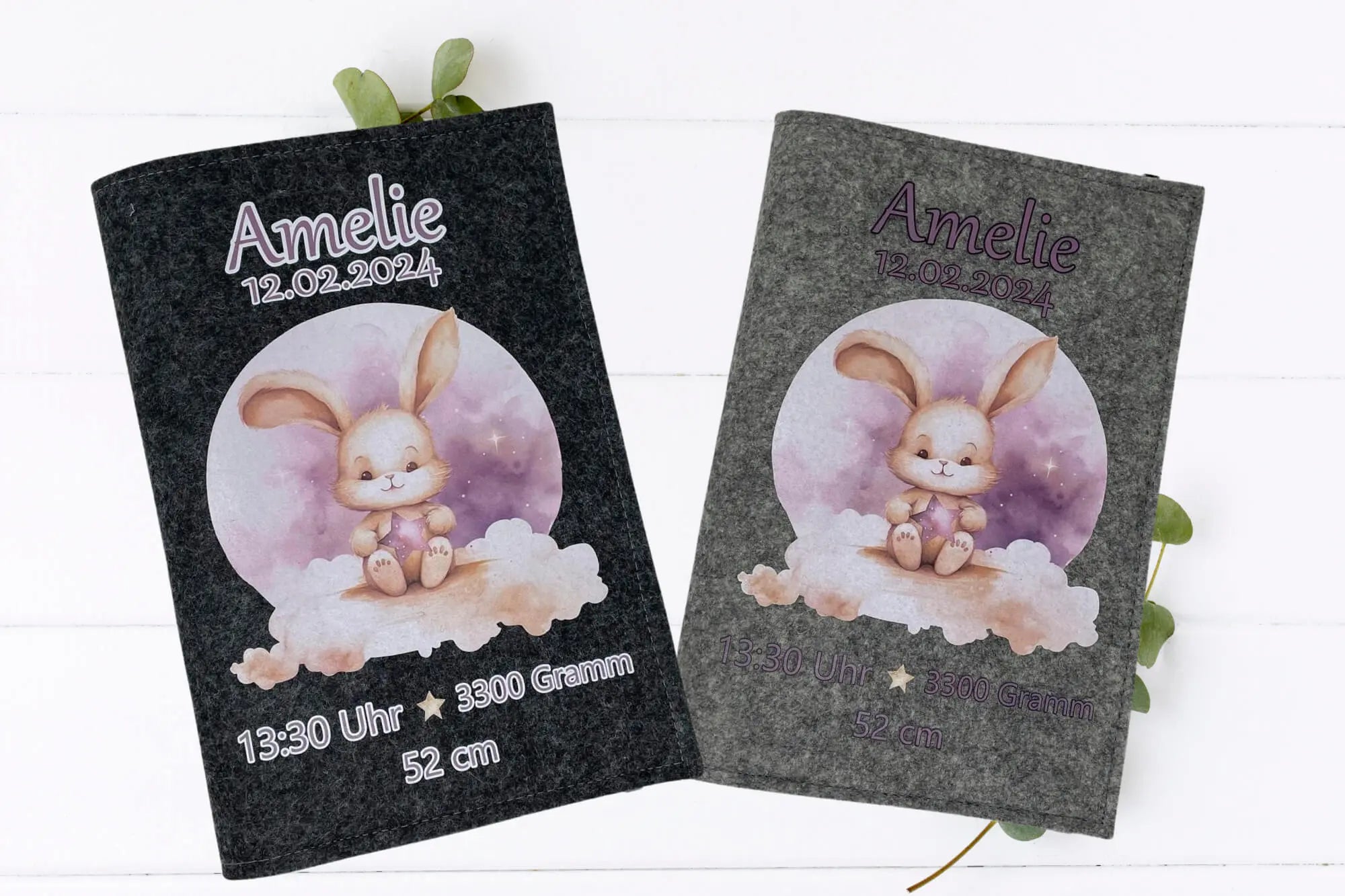 Illustrative U-Heft-Hülle mit Hasenbaby auf Wolke, lila Stern und farbenfrohem Himmel in Rosa und Violett