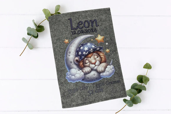 Filzhülle fürs U-Heft mit nächtlichem Design: Kuscheliger Löwe auf Wolken und Mond, umgeben von Sternen.