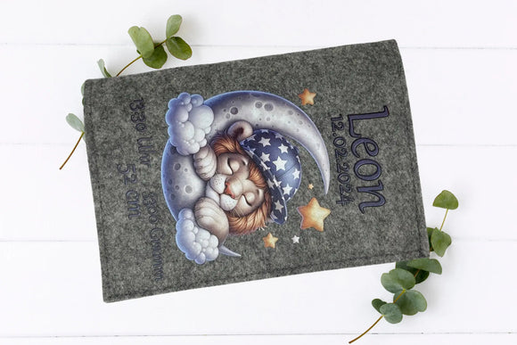 Zauberhafte U-Heft-Hülle mit Löwenmotiv auf dem Mond – ideal als liebevolles Geschenk zur Geburt.