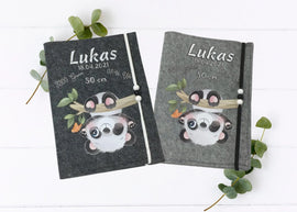 U-Heft-Hülle aus grauem Filz mit süßem Panda, der kopfüber an einem Ast hängt.