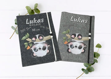 U-Heft-Hülle aus grauem Filz mit süßem Panda, der kopfüber an einem Ast hängt.