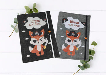 Personalisierte U-Heft-Hülle aus grauem Filz mit Fuchs als Pirat, Augenklappe und Schwert.