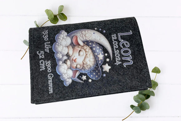 Handgemachte U-Heft-Hülle mit schlafendem Schaf in einer Wolkenlandschaft mit Halbmond und Sternen.