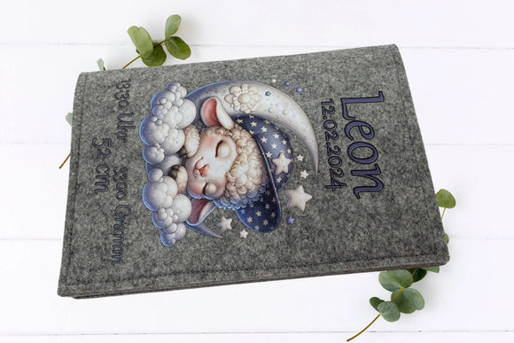 Flauschiges Schaf schläft auf Halbmond, umgeben von kleinen Sternen – süßes Design für U-Heft-Hülle.