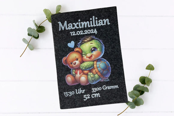 Individuell bedruckte Filzhülle mit Baby-Schildkröte, Teddy und Geburtsdaten – ideal zur Aufbewahrung des Untersuchungsheftes.