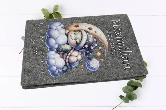 U-Heft-Hülle mit dunkelgrauem Filz, schlafender Schildkröte, Halbmond und kleinen Sternen – beruhigendes Design.