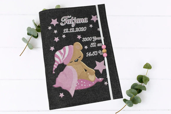 Filzhülle für das U-Heft mit liebevoll gestaltetem Teddymotiv, rosa Schlafanzug und kleinen Sternen.