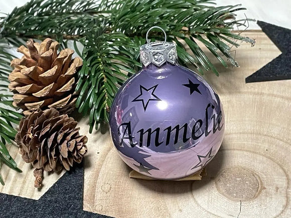 Matte lila Weihnachtskugel mit schwarzer Beschriftung „Amelie“ und Sternen