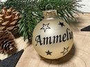 Glaskugel in Champagnerfarbe mit schwarzer Schrift „Amelie“ und Sternen