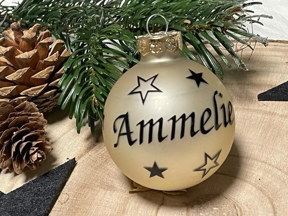 Glaskugel in Champagnerfarbe mit schwarzer Schrift „Amelie“ und Sternen
