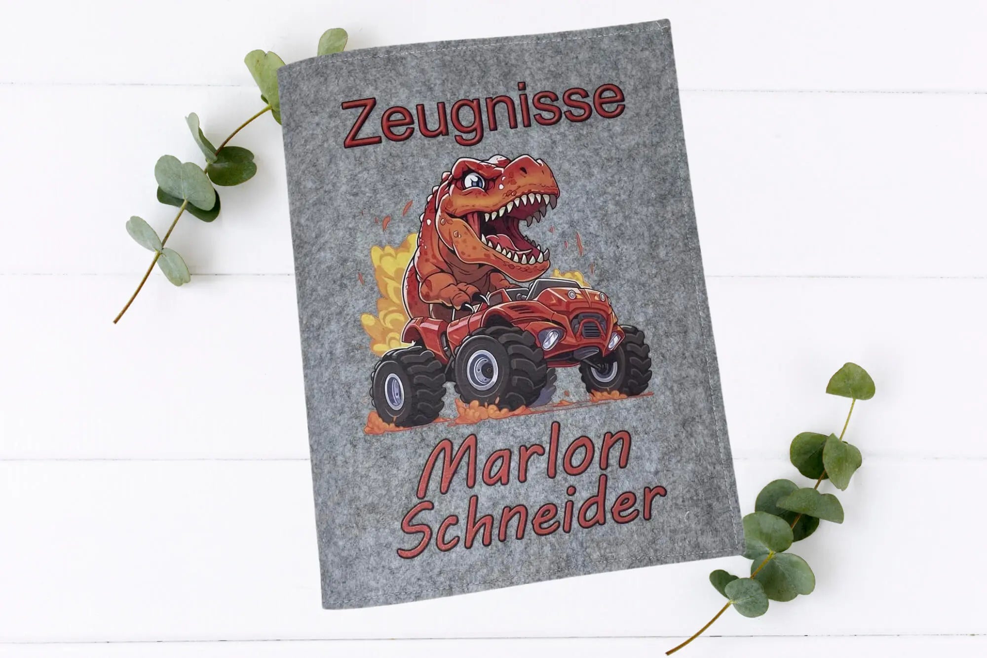 Filzmappe zur Aufbewahrung von Zeugnissen mit feuerspuckendem T-Rex auf Monstertruck, Namen individuell anpassbar.